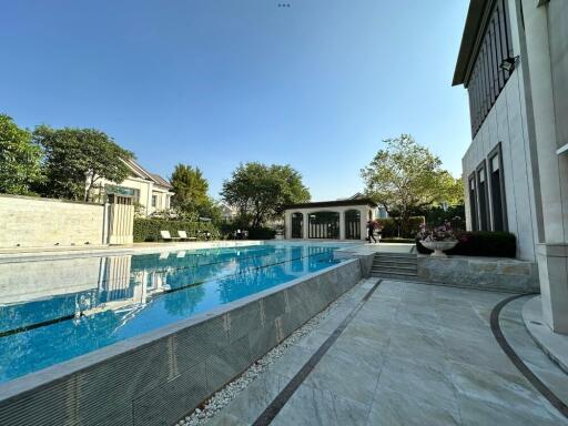 Outdoor swimming pool next to a luxury house