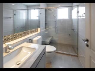 Modern bathroom with large glass-enclosed shower and sink vanity