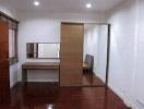 Spacious bedroom with wooden floor and mirrored wardrobe