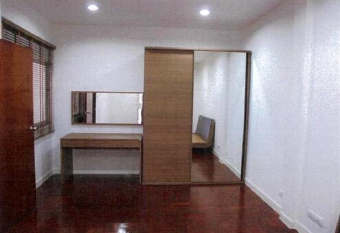 Spacious bedroom with wooden floor and mirrored wardrobe