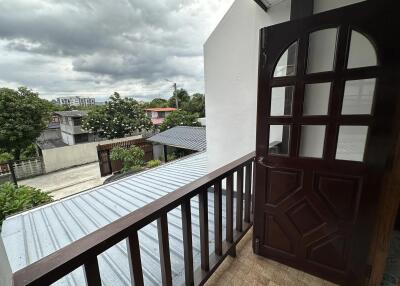 Balcony view with brown wooden door and railing