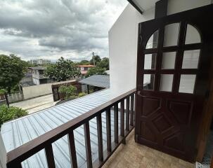 Balcony view with brown wooden door and railing