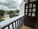 Balcony view with brown wooden door and railing