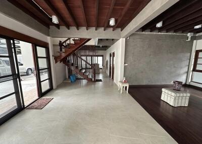 Modern living area with wooden staircase and large windows