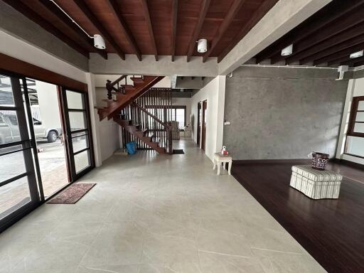 Modern living area with wooden staircase and large windows