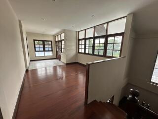 Spacious main living area with wooden flooring and large windows