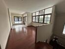 Spacious main living area with wooden flooring and large windows