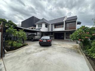 Exterior view of a modern house with driveway and cars