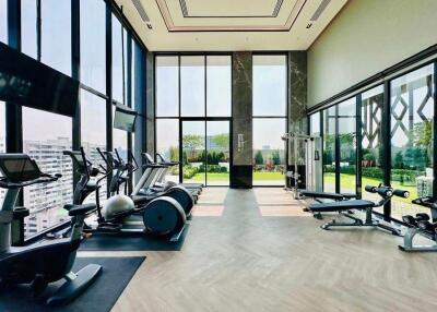 Modern gym with exercise equipment and large windows