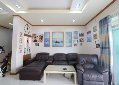 Cozy living room with brown leather sofas, artwork, and exercise bike