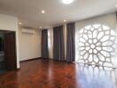 Spacious living room with large window and wooden floor