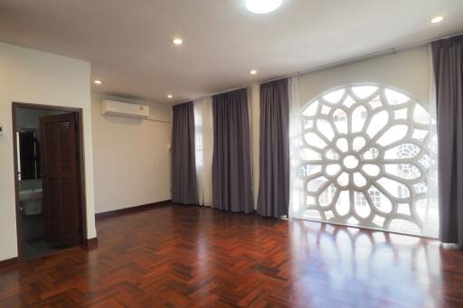 Spacious living room with large window and wooden floor