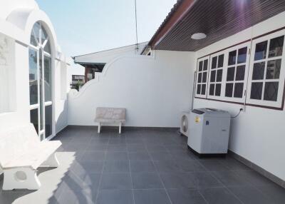 Outdoor balcony with seating and air conditioning unit