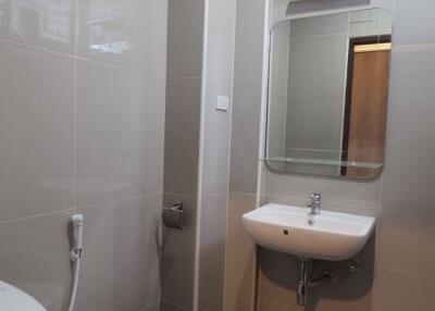 Modern bathroom with sink, toilet, and mirror