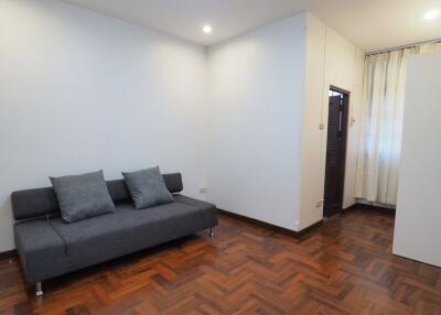 Minimalist living room with gray couch and wooden flooring