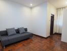 Minimalist living room with gray couch and wooden flooring