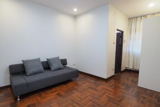 Minimalist living room with gray couch and wooden flooring