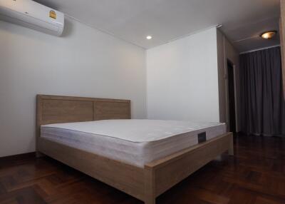 Bedroom with wooden bed frame and parquet flooring