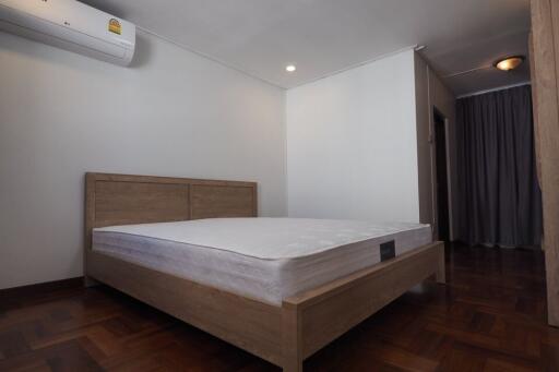 Bedroom with wooden bed frame and parquet flooring