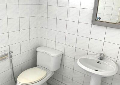 Bathroom with white tiled walls and checkered floor