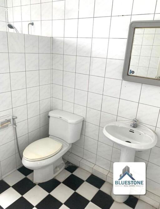 Bathroom with white tiled walls and checkered floor