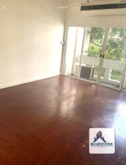 Spacious living area with hardwood flooring and large window