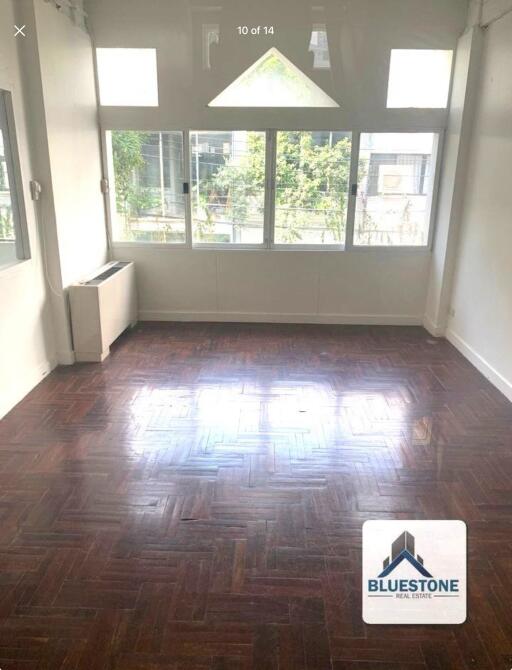 Bright and spacious living room with large windows and polished hardwood floor