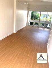 Long living area with wooden flooring and large windows