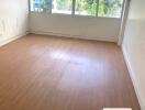 Empty room with hardwood floor and large windows