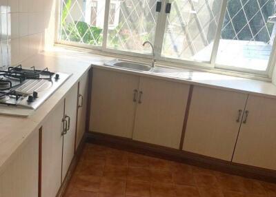 Residential kitchen with large window and tiled floor