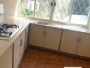 Residential kitchen with large window and tiled floor