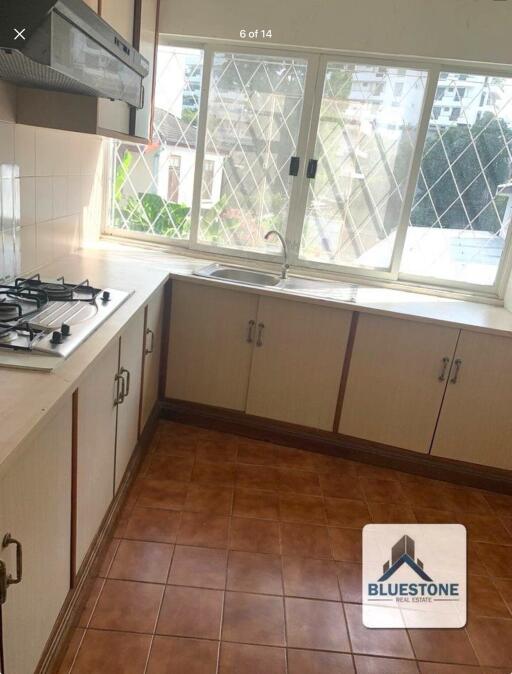 Residential kitchen with large window and tiled floor