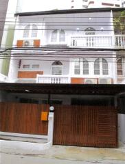 Front view of a multi-level building with balconies and a gated entrance