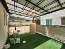 Covered outdoor space with green artificial turf and exercise equipment