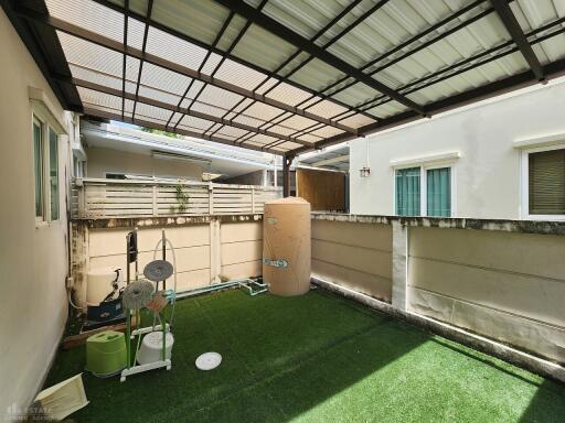 Covered outdoor space with green artificial turf and exercise equipment