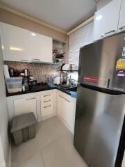 Modern kitchen with white cabinets and stainless-steel refrigerator