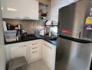 Modern kitchen with white cabinets and stainless-steel refrigerator