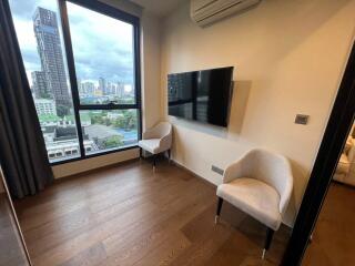 Modern living room with large window, air conditioning, and wall-mounted TV