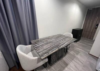 Modern dining area with marble-top dining table and cushioned chairs