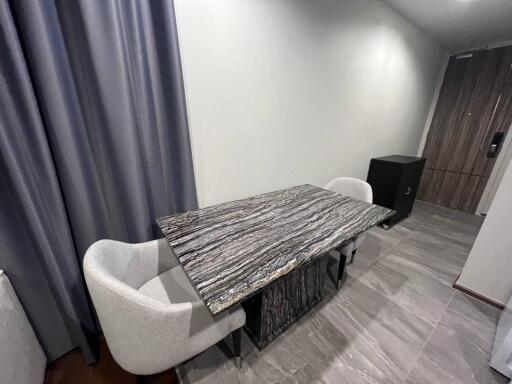 Modern dining area with marble-top dining table and cushioned chairs