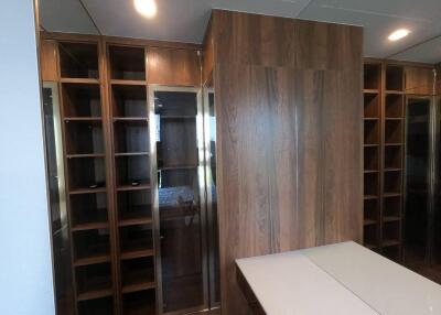 Spacious walk-in closet with wooden shelves and cabinets