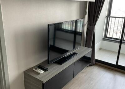 Modern living room with TV, shelves, and a balcony