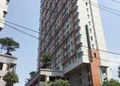 High-rise residential building with greenery and signage