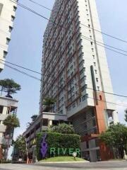 High-rise residential building with greenery and signage