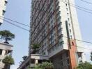 High-rise residential building with greenery and signage