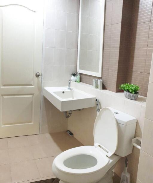 Modern bathroom with a sink, toilet, and mirror