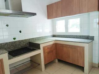 Well-lit kitchen with wooden cabinets and granite countertops