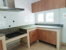 Well-lit kitchen with wooden cabinets and granite countertops