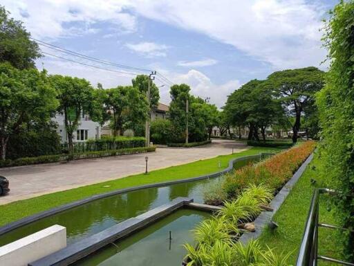 View of landscaped garden with water features and surrounding buildings