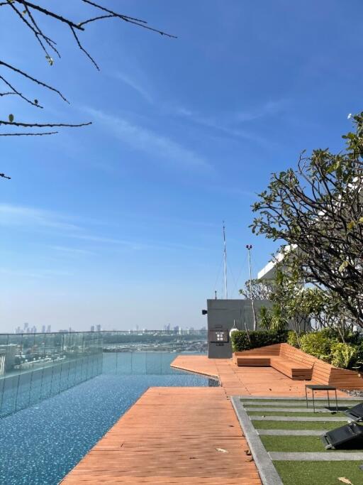 Rooftop pool with city view and seating area